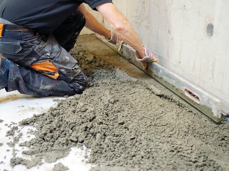 Lay cement screed and level it by hand using the leveling bar