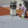 Baustelle: Flüssige Kunststoffabdichtung wird mit Rolle auf Dach aufgetragen