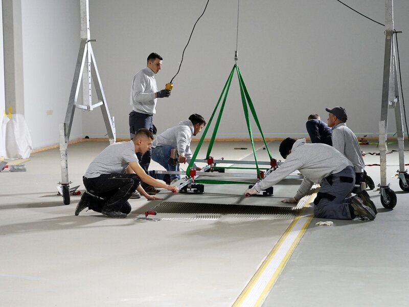 Large format tiles with lifting device into adhesive bed