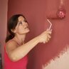 Wand wird mit Farbrolle in rot gestrichen