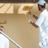 Baustelle: Maler rollen Fassadenfarbe auf Wand